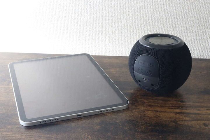 タブレット端末と黒いボール形スピーカーを並べて置いている様子