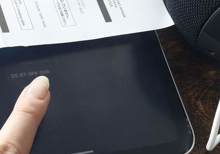 タブレット端末の画面に表示されたデバイス名を指でタップしているところ