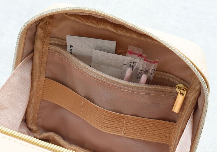 ポーチの内側にあるファスナーポケットに絆創膏やサンプル品が収納されている様子