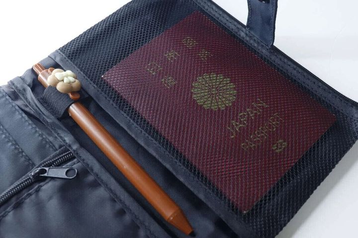 パスポートケースのメッシュポケットにパスポートとペンを入れた俯瞰