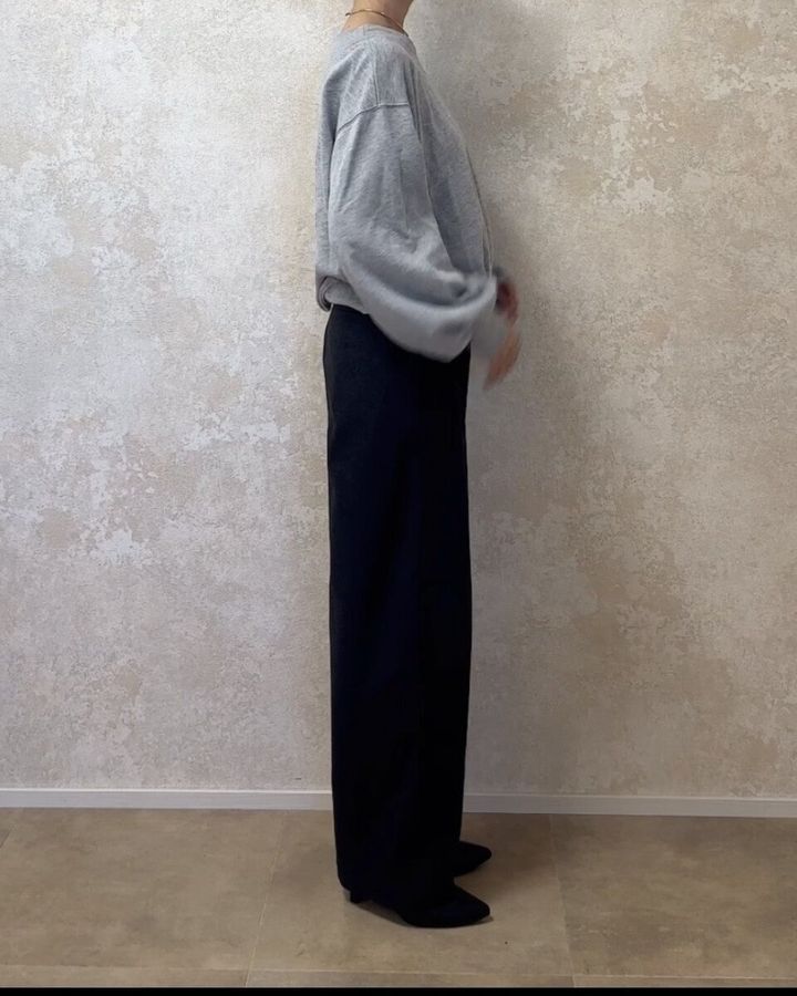 グレーのスウェットとバレルパンツを合わせた全身の横向き姿