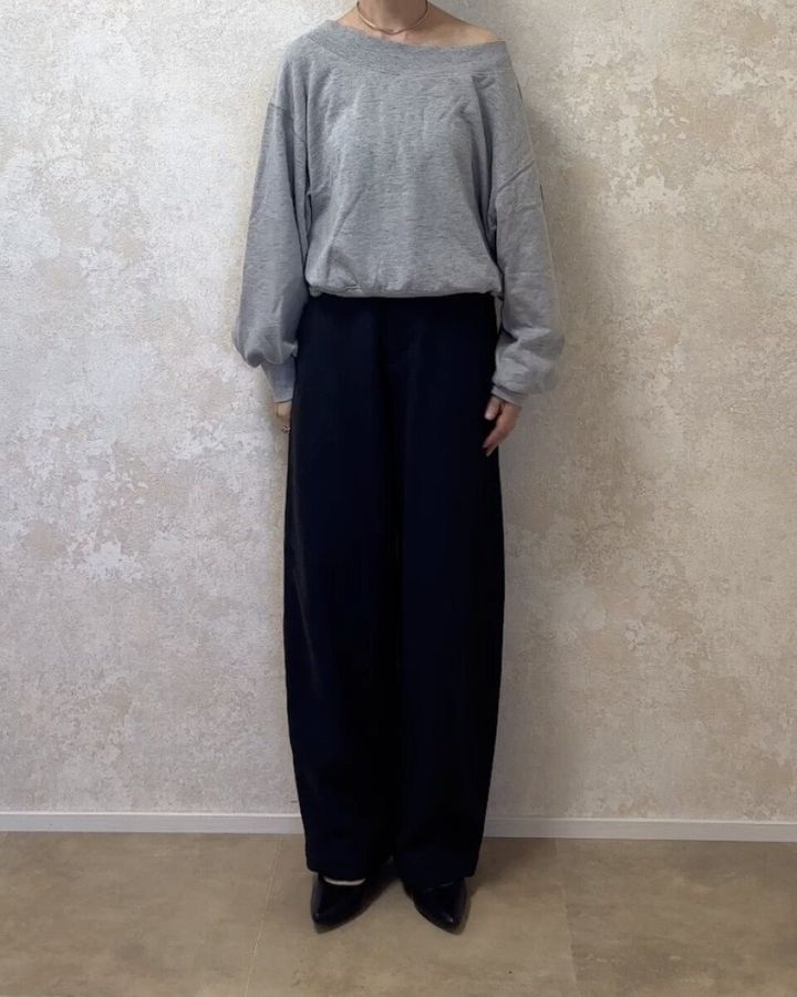 グレーのスウェットにダークグレーのパンツを合わせた全身の正面姿