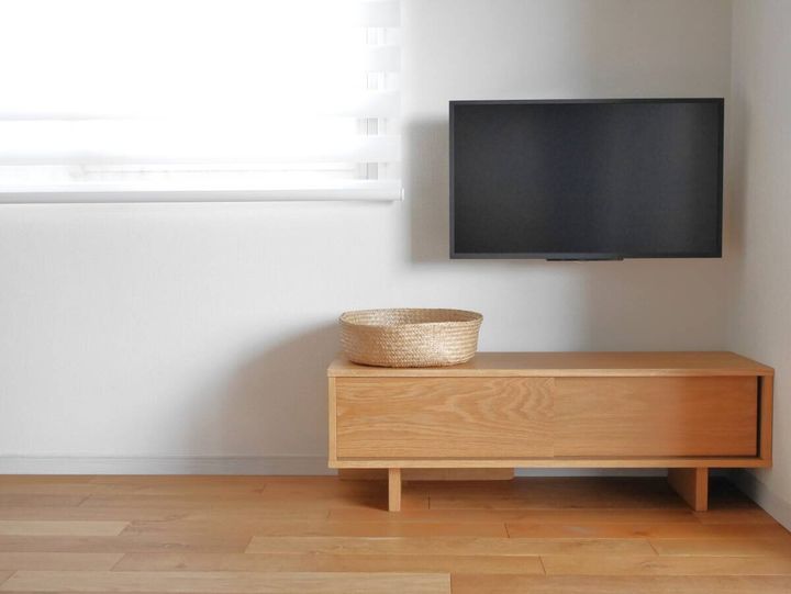 すっきりと片付いたテレビボードと壁掛けテレビがあるリビングの様子