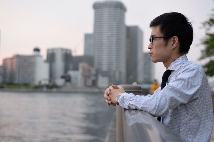 欄干に肘をかけたそがれている男性