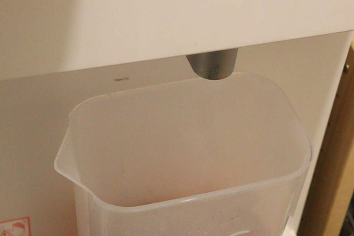 ウォーターサーバーの下にウォーターポットを置いてお湯を注ぐ準備をしている様子
