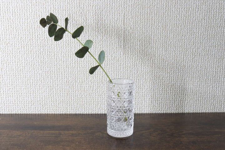 切子細工風のガラス製ミニ花瓶に一輪のユーカリの葉が挿してある様子