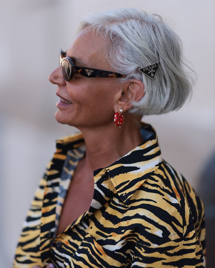 シルバーのショートヘアにプラダのブラックのトライアングルバレッタ纏う大人女性