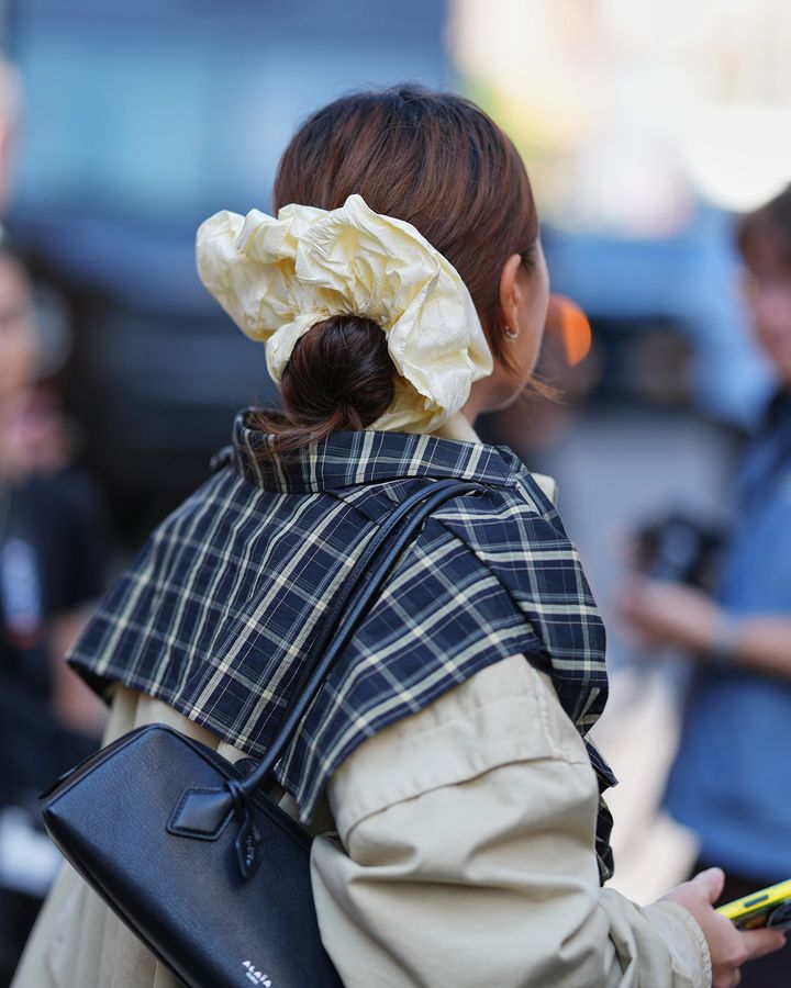 ホワイトのビッグシュシュで髪をまとめた大人の女性のバックスタイル