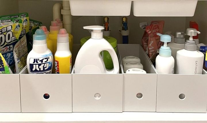 洗面台の下の収納棚にファイルボックスを並べて洗剤やストック品を整理している様子