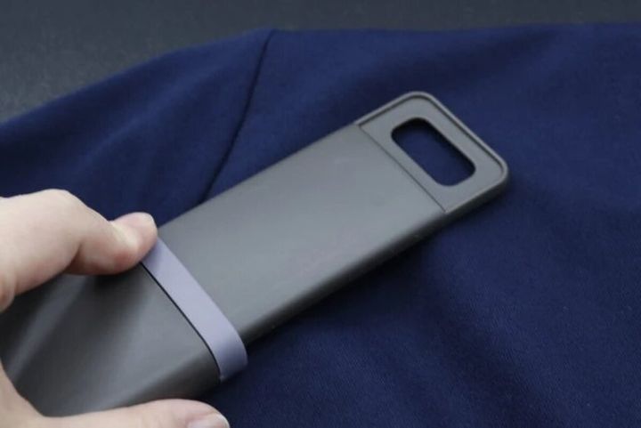 紺色の衣服の上でホコリ取りブラシを使用している様子