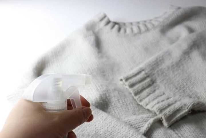 白いニットの衣類に向けて静電気ガードミストを噴射している様子