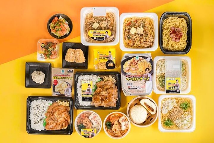 黄色とオレンジの背景に並べられたファミマとリュウジコラボの全9商品の俯瞰写真