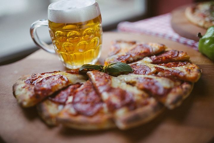レストランの素朴なテーブルに並んだ、ビールとピザです。